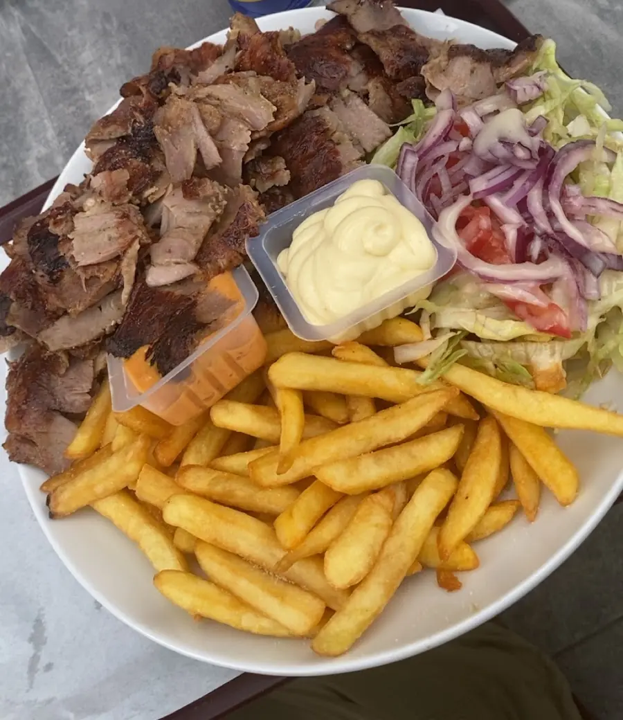 Assiette kebab avec frites, salade, oignons rouges et sauce blanche